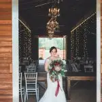 bride standing at the barn entrance door at Kelly Farms in St. Augustine, FL